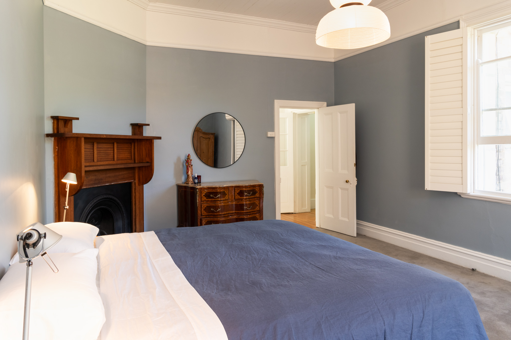 Bedroom with quality linen bedding and decorative fireplace